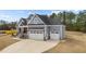 Side view of home showcasing the three-car garage and manicured lawn at 262 Hook Dr # 12, Fuquay Varina, NC 27526