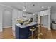 Elegant kitchen with white cabinets, brass fixtures, a navy island and a view to another space at 262 Hook Dr # 12, Fuquay Varina, NC 27526