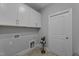 Well-lit laundry room with white cabinets, tile floors, and modern fixtures, offers convenience at 262 Hook Dr # 12, Fuquay Varina, NC 27526