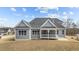 Rear view of home showcases gray siding, a dark roof, and backyard patio at 262 Hook Dr # 12, Fuquay Varina, NC 27526