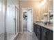 Bright bathroom with a glass shower, double vanity, granite countertops, and a linen closet in view at 100 Old Garden Ln, Youngsville, NC 27596