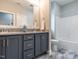 Bathroom featuring a double vanity with grey cabinets and granite countertops, plus a shower and toilet at 100 Old Garden Ln, Youngsville, NC 27596