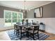 Dining room featuring modern chandelier, wainscoting, large windows, and a striking area rug at 100 Old Garden Ln, Youngsville, NC 27596
