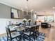 Well-lit dining room with stylish decor including a modern light fixture and blue patterned rug, next to the kitchen at 100 Old Garden Ln, Youngsville, NC 27596