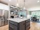 Bright kitchen with an island, stainless steel appliances, and a view into the living and dining areas at 100 Old Garden Ln, Youngsville, NC 27596
