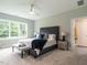 Serene main bedroom with a plush bed, neutral tones, and a window overlooking the backyard at 100 Old Garden Ln, Youngsville, NC 27596