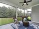 Stylish screened-in porch with comfortable seating and views of the lush green landscape at 100 Old Garden Ln, Youngsville, NC 27596
