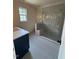 Modern bathroom featuring gray shower, tile floor, blue vanity, and recessed lights at 2227 Wheeler Rd, Raleigh, NC 27607