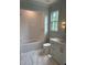 Bright bathroom featuring a tub-shower combo, white marble vanity, and decorative lighting at 2227 Wheeler Rd, Raleigh, NC 27607
