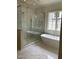 Bright bathroom featuring a freestanding tub, glass shower enclosure, and a window with natural light at 2227 Wheeler Rd, Raleigh, NC 27607