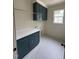 Modern laundry room with dark cabinets, white countertops, and tiled floor at 2227 Wheeler Rd, Raleigh, NC 27607