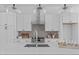 Bright kitchen featuring a spacious island, stainless steel appliances, and elegant lighting at 2014 Moody Ln, Durham, NC 27701