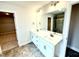 Bathroom featuring double vanity, framed mirror, and a view into the shower and walk-in closet at 152 Southern Estates Dr, Sanford, NC 27330