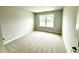Well-lit bedroom featuring light walls, neutral carpet, and bright window view at 152 Southern Estates Dr, Sanford, NC 27330