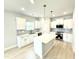 Modern kitchen with white cabinets, stainless steel appliances, an island, and pendant lighting at 152 Southern Estates Dr, Sanford, NC 27330