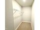 Compact walk-in closet featuring wire shelving and neutral carpet at 152 Southern Estates Dr, Sanford, NC 27330