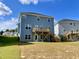 Back exterior featuring a wooden deck with stairs leading to a spacious backyard at 303 Bishop Ln, Sanford, NC 27330