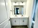 Bathroom featuring a double sink vanity, ample lighting, and neutral wall paint at 303 Bishop Ln, Sanford, NC 27330