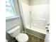 Bright bathroom featuring a standard white toilet and shower-tub combo at 303 Bishop Ln, Sanford, NC 27330