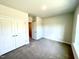 Cozy bedroom featuring plush carpeting, a double-door closet, and a window offering natural light at 303 Bishop Ln, Sanford, NC 27330