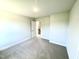 Neutral bedroom features a door and window to let in natural light, with neutral carpeting at 303 Bishop Ln, Sanford, NC 27330