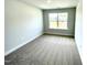 Bright bedroom featuring neutral walls, plush carpet and a window offering neighborhood views at 303 Bishop Ln, Sanford, NC 27330