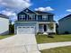 Charming two-story home features a covered front porch and a two-car garage with blue siding at 303 Bishop Ln, Sanford, NC 27330