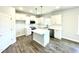 Modern kitchen with white cabinets, an island, stainless steel appliances and hardwood floors at 303 Bishop Ln, Sanford, NC 27330