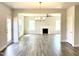 View of the living room with hardwood floors and fireplace with view into Kitchen at 303 Bishop Ln, Sanford, NC 27330