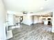 Open-concept living area with hardwood floors, leading to the kitchen and staircase at 303 Bishop Ln, Sanford, NC 27330