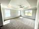 Spacious main bedroom with tray ceiling, fan, and ample natural light from multiple windows at 303 Bishop Ln, Sanford, NC 27330