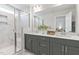 Well-lit bathroom showcasing double sinks, gray cabinets, white countertops and a glass enclosed shower at 125 Sugar Run Dr # 26, Fuquay Varina, NC 27526