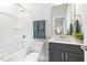 A simple bathroom features a combination shower and tub, toilet, and sink with gray cabinet at 125 Sugar Run Dr # 26, Fuquay Varina, NC 27526