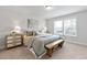 Well-lit bedroom with a comfortable bed and a rustic wooden bench at 125 Sugar Run Dr # 26, Fuquay Varina, NC 27526