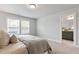 Bright bedroom with a large window, neutral walls, and a glimpse into the connected bathroom at 125 Sugar Run Dr # 26, Fuquay Varina, NC 27526