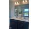 Modern bathroom featuring dual sinks with chrome fixtures, a large mirror and view to the outside at 323 Chestnut Oak Ln, Lillington, NC 27546
