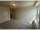 A bright bedroom features neutral walls, carpet, a window for natural light and a door with white trim at 323 Chestnut Oak Ln, Lillington, NC 27546