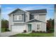 Two-story home with gray siding, white garage door and teal front door at 323 Chestnut Oak Ln, Lillington, NC 27546