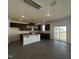 Modern kitchen features dark cabinets, granite countertops, and stainless steel appliances with an island at 323 Chestnut Oak Ln, Lillington, NC 27546