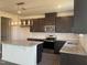Well-lit kitchen with stainless steel appliances, granite countertops, and a large island with seating at 323 Chestnut Oak Ln, Lillington, NC 27546