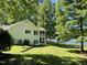 Backyard view of a white brick home featuring a screened porch and waterfront access at 3309 Westcott Cir, Sanford, NC 27330