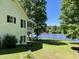 Backyard view of a white brick home featuring a screened porch and waterfront access at 3309 Westcott Cir, Sanford, NC 27330