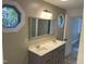 Neutral bathroom featuring a double sink vanity, a large mirror, and a window at 3309 Westcott Cir, Sanford, NC 27330
