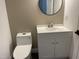 Cozy bathroom featuring a modern toilet, single sink vanity, updated fixtures, and a round mirror at 3309 Westcott Cir, Sanford, NC 27330