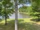 Scenic lake view with mature trees, green lawn, and wildlife, creating a peaceful and natural setting at 3309 Westcott Cir, Sanford, NC 27330