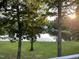 Serene lake view from the deck, framed by mature trees and lush greenery at 3309 Westcott Cir, Sanford, NC 27330