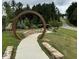 Inviting community feature with a stone walkway, circular metal structure, lush landscaping, and serene pathway at 2633 Trifle Ln, Wake Forest, NC 27587