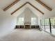 Open-concept living room featuring vaulted ceiling, wooden beams, and large sliding doors to the patio at 2633 Trifle Ln, Wake Forest, NC 27587