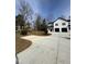 Modern farmhouse with white siding, black trim, two-car garage, and large driveway at 329 Roxboro St, Haw River, NC 27258