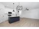 Open concept kitchen with white cabinets and dark island at 329 Roxboro St, Haw River, NC 27258